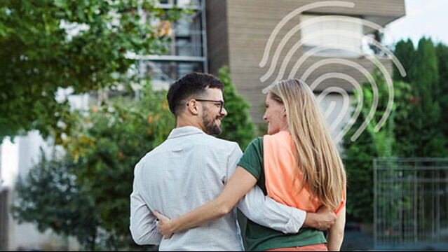 Een koppel kijkt elkaar aan voor de oprit van hun woning.